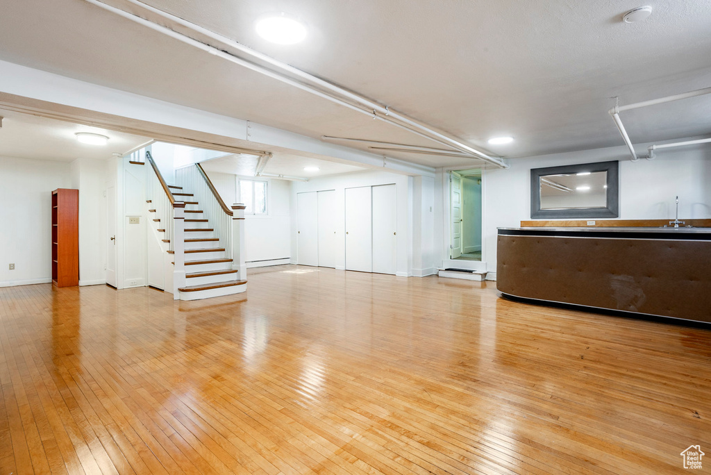 Unfurnished living room featuring stairs and hardwood / wood-style floors