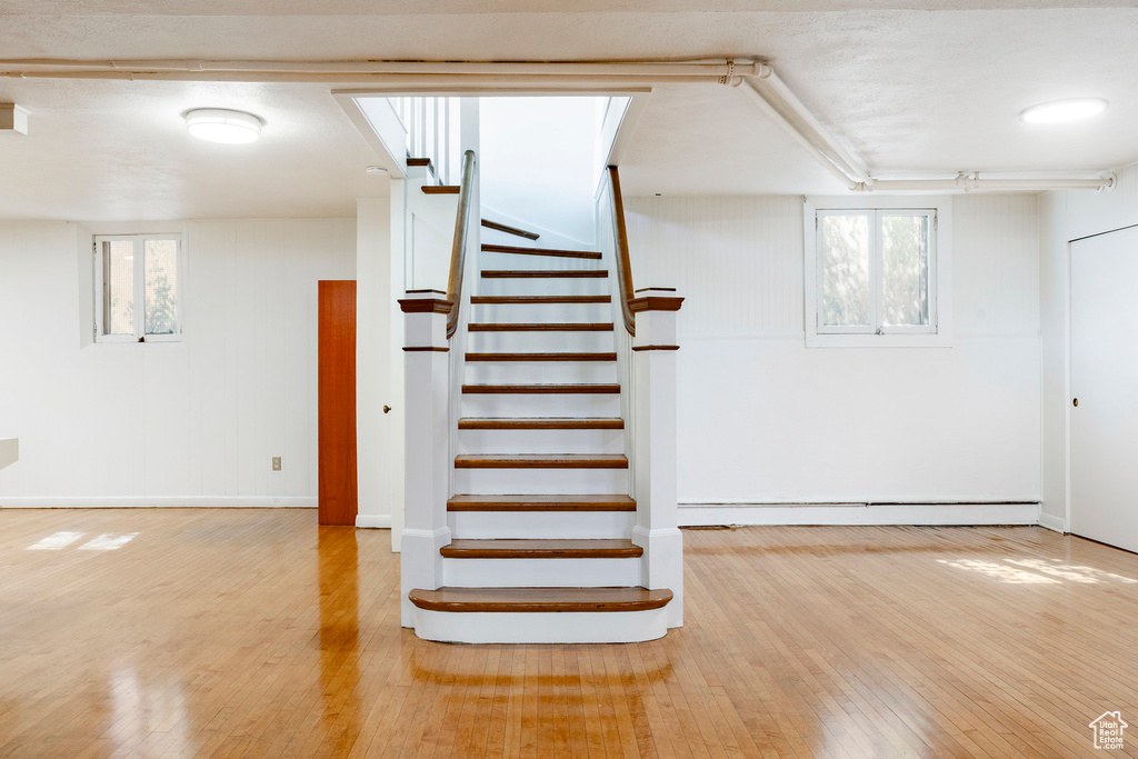 Stairway featuring wood finished floors