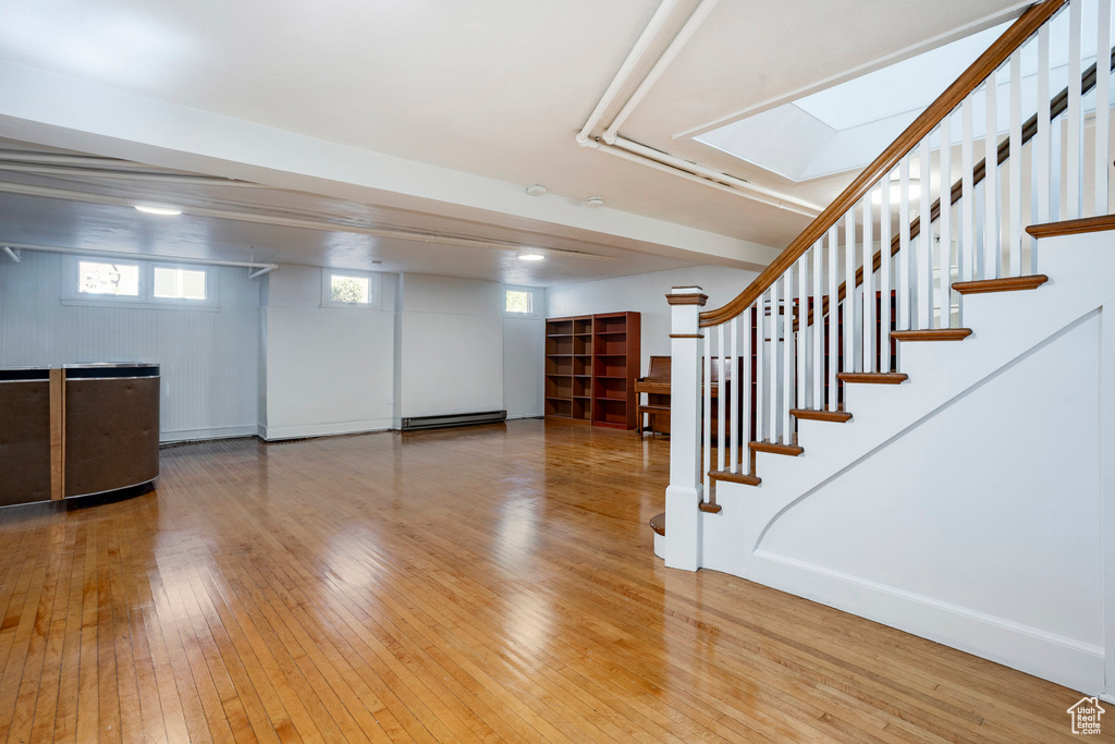 Basement featuring wood-type flooring and stairs