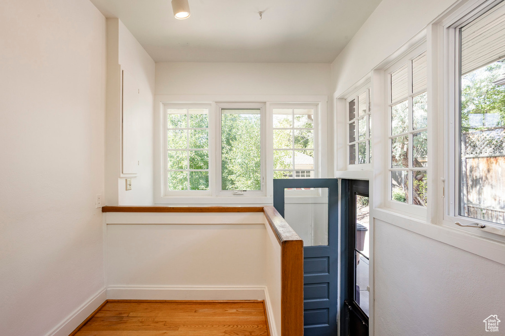 Stairway with wood finished floors and baseboards