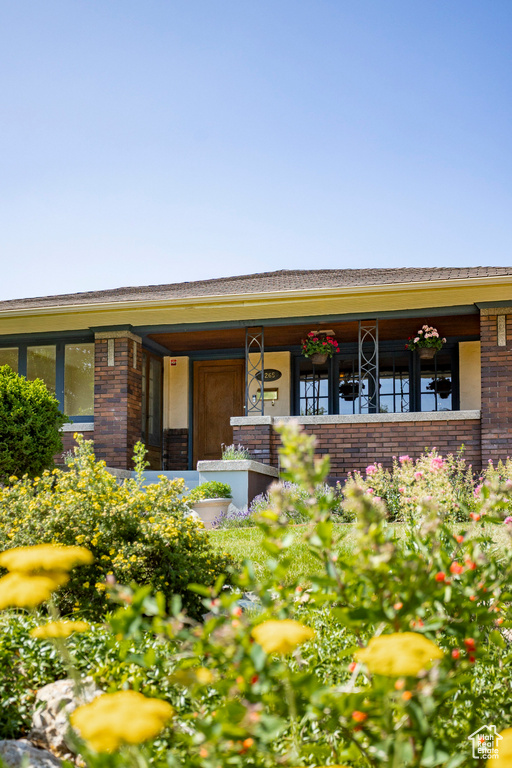 View of front of house with brick siding and covered porch