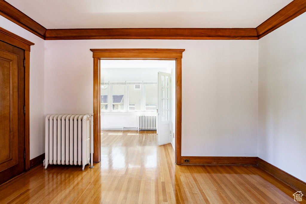 Corridor featuring radiator and light wood finished floors