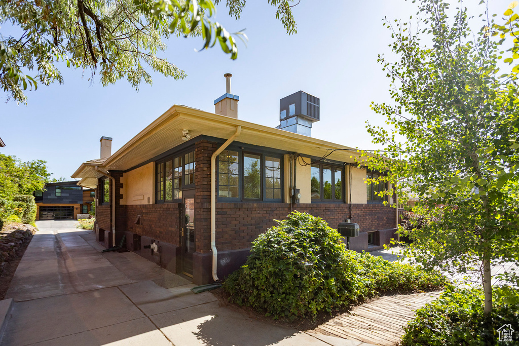 View of front of property with a chimney and brick siding