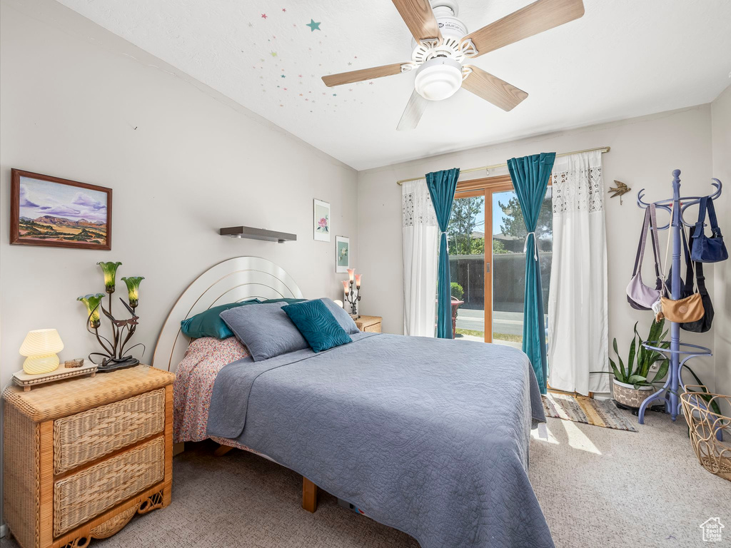 Carpeted bedroom featuring access to outside and ceiling fan