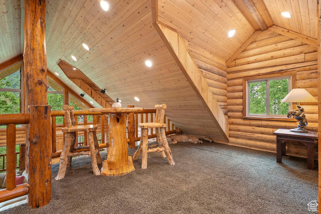 Interior space with log walls, carpet, high vaulted ceiling, plenty of natural light, and recessed lighting