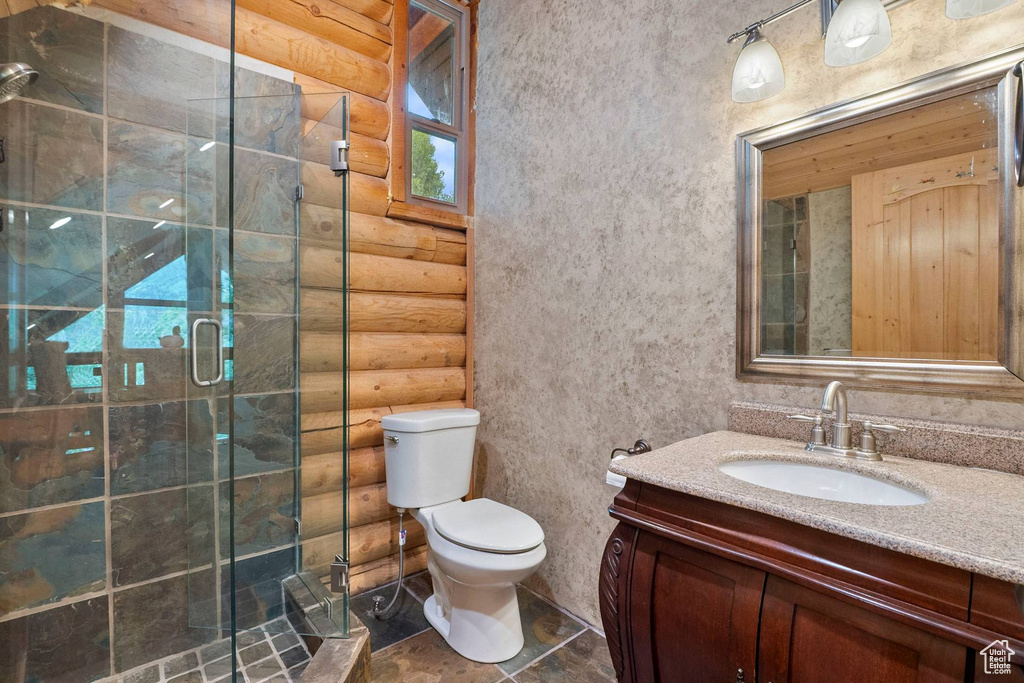 Bathroom featuring rustic walls, vanity, and a shower stall