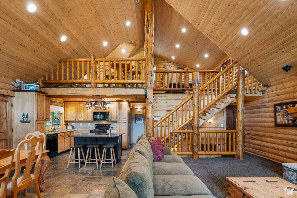 Living room with high vaulted ceiling, stairs, recessed lighting, wood ceiling, and log walls