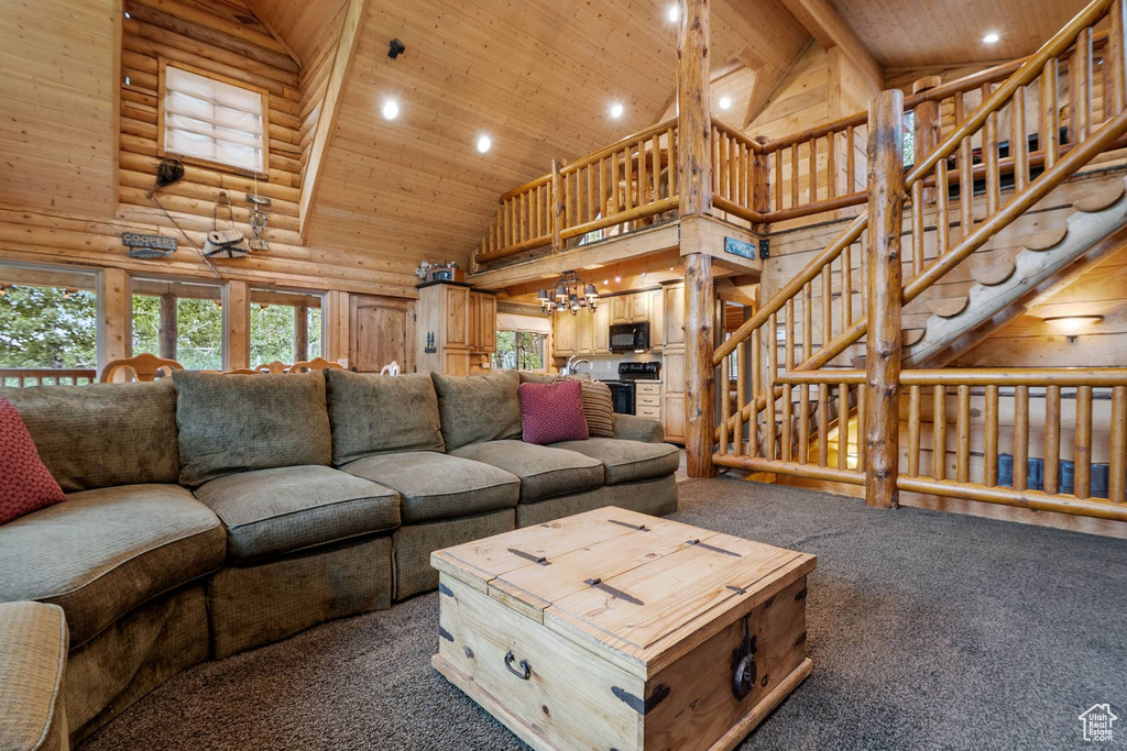 Living area with high vaulted ceiling, carpet floors, wood ceiling, recessed lighting, and a chandelier