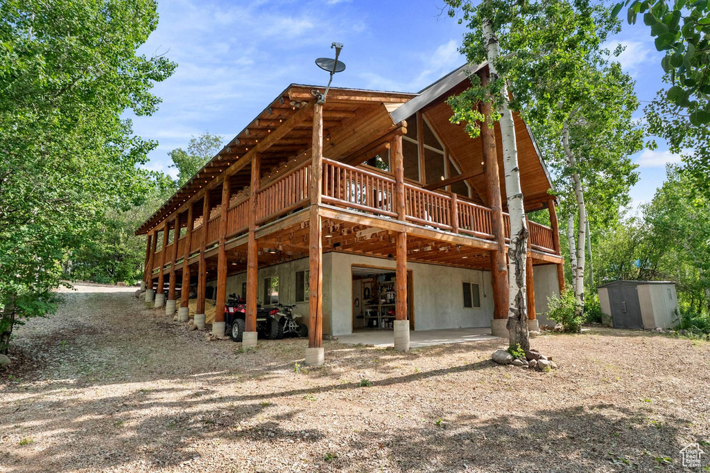 Back of house with a storage shed and a deck