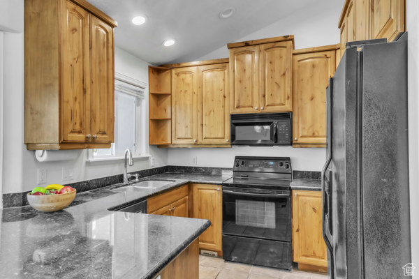 Kitchen with black appliances, open shelves, dark stone countertops, lofted ceiling, and light tile patterned floors