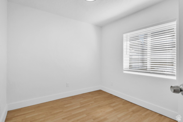 Spare room with baseboards and light wood-style floors
