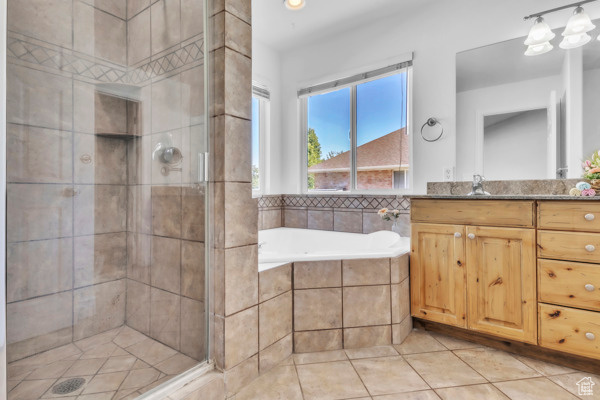 Full bath with vanity, a stall shower, a garden tub, and tile patterned flooring