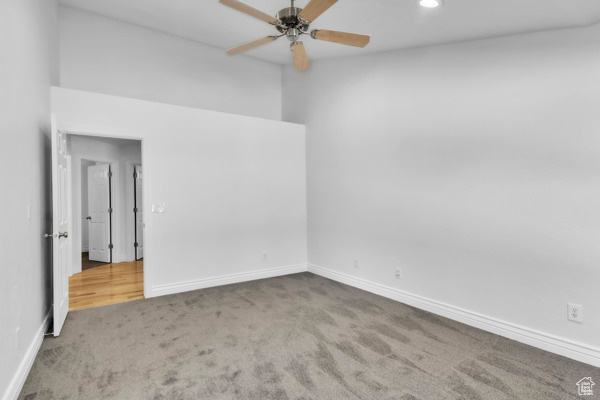 Carpeted empty room with a ceiling fan and recessed lighting