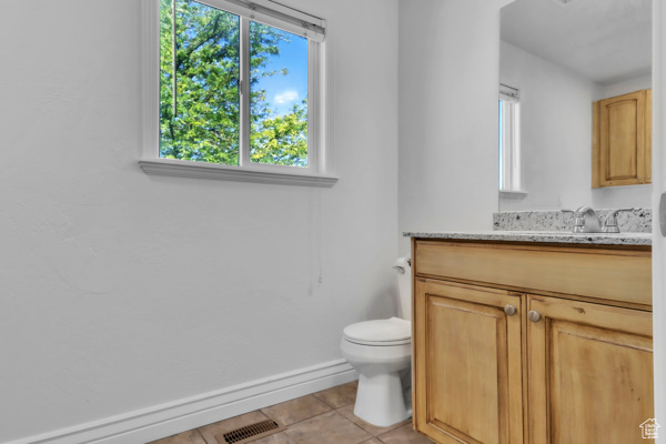 Bathroom with vanity, tile patterned flooring, and healthy amount of natural light