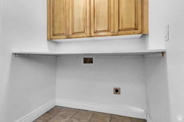 Washroom featuring hookup for an electric dryer, washer hookup, and cabinet space