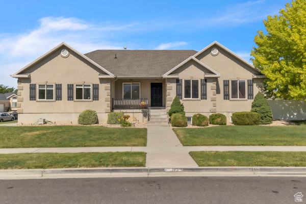 Ranch-style home featuring stucco siding, a front yard, and a porch