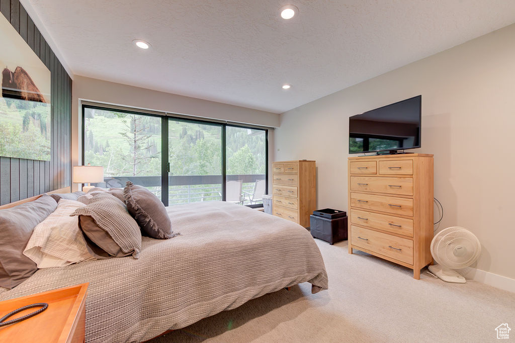 Bedroom featuring access to outside, light carpet, and recessed lighting