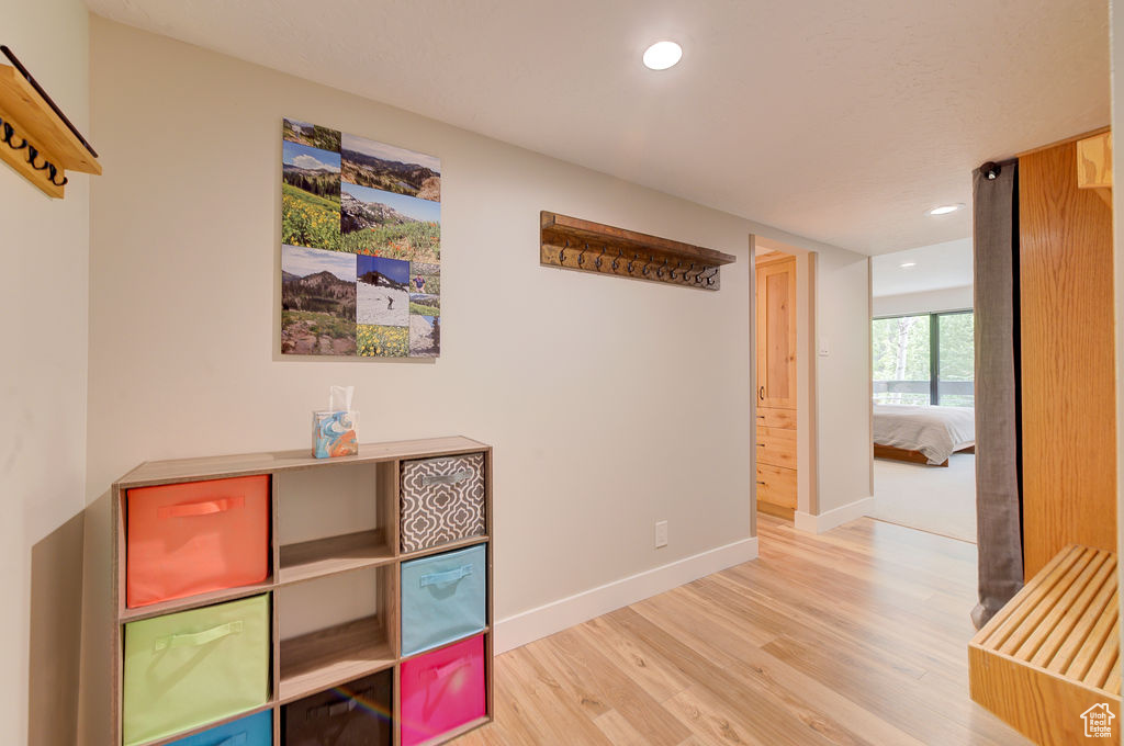 Corridor with light wood-style floors and recessed lighting