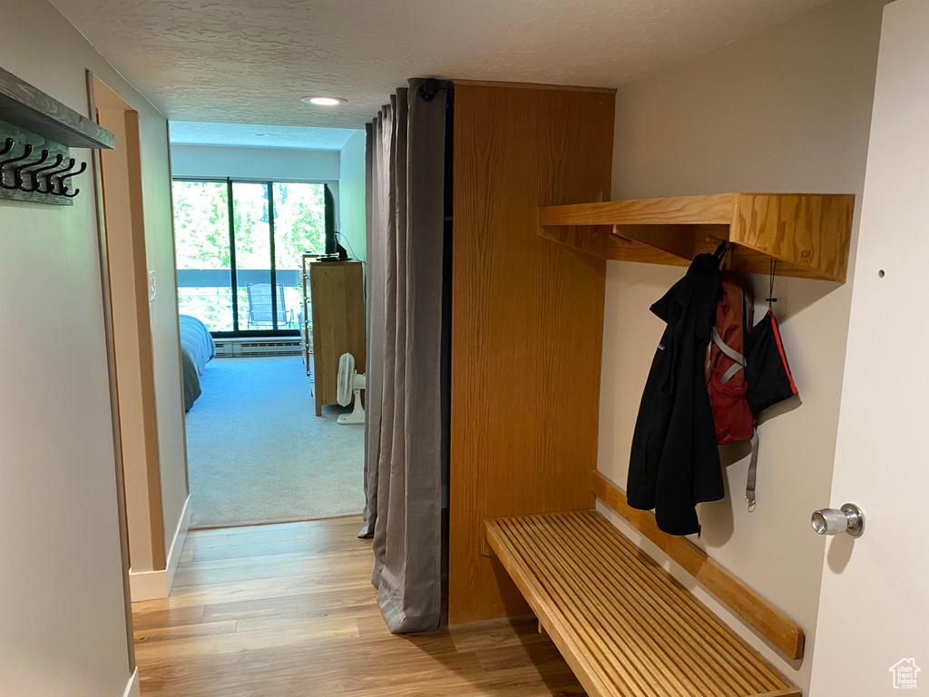 Mudroom with light wood-type flooring and a textured ceiling
