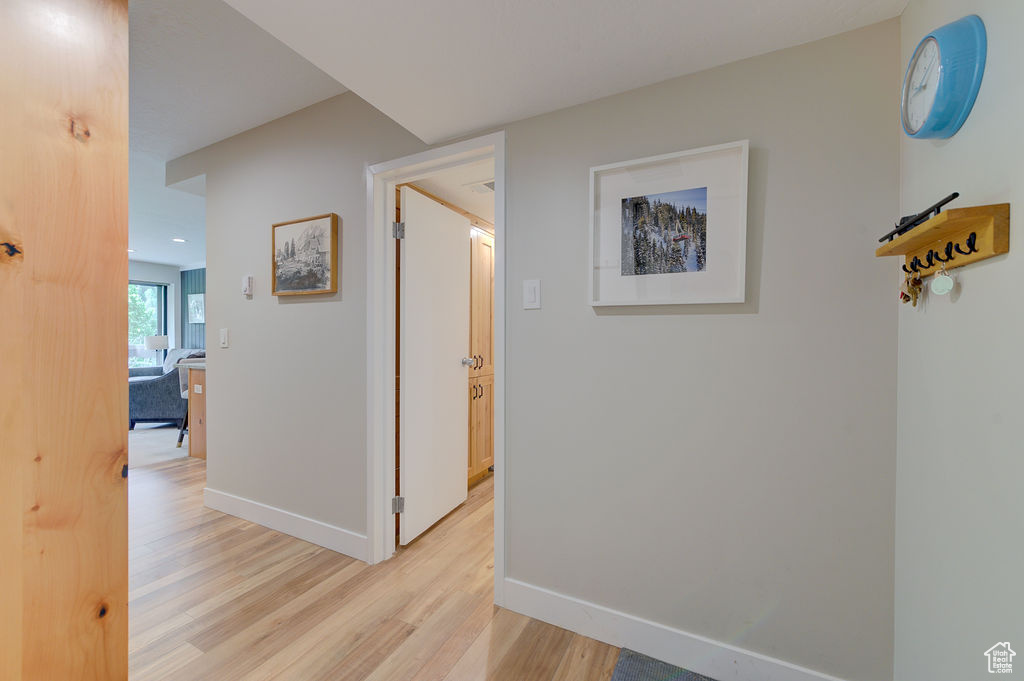 Corridor featuring light wood finished floors and baseboards