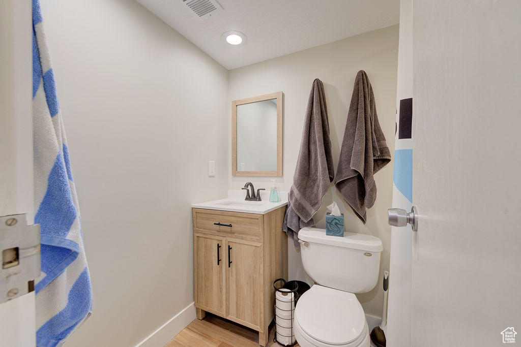 Half bath with vanity and wood finished floors