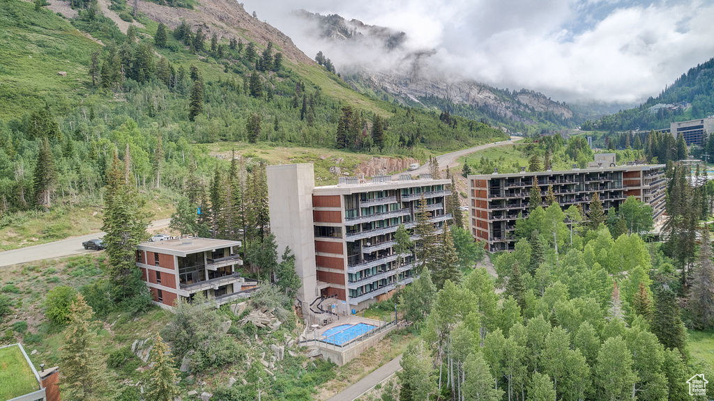 View of property with a mountain view and a forest view