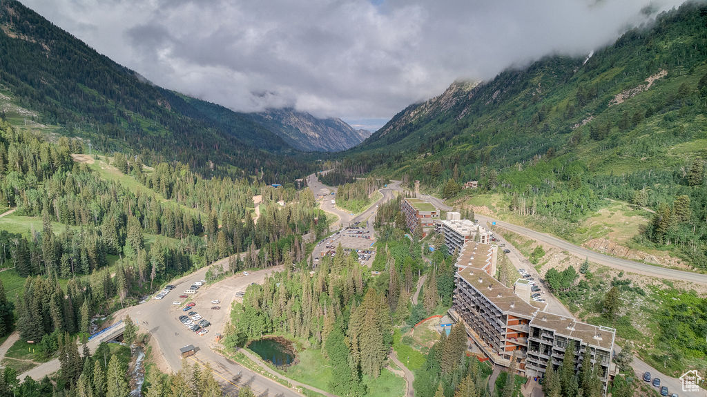 Aerial view of property's location featuring mountains and a forest