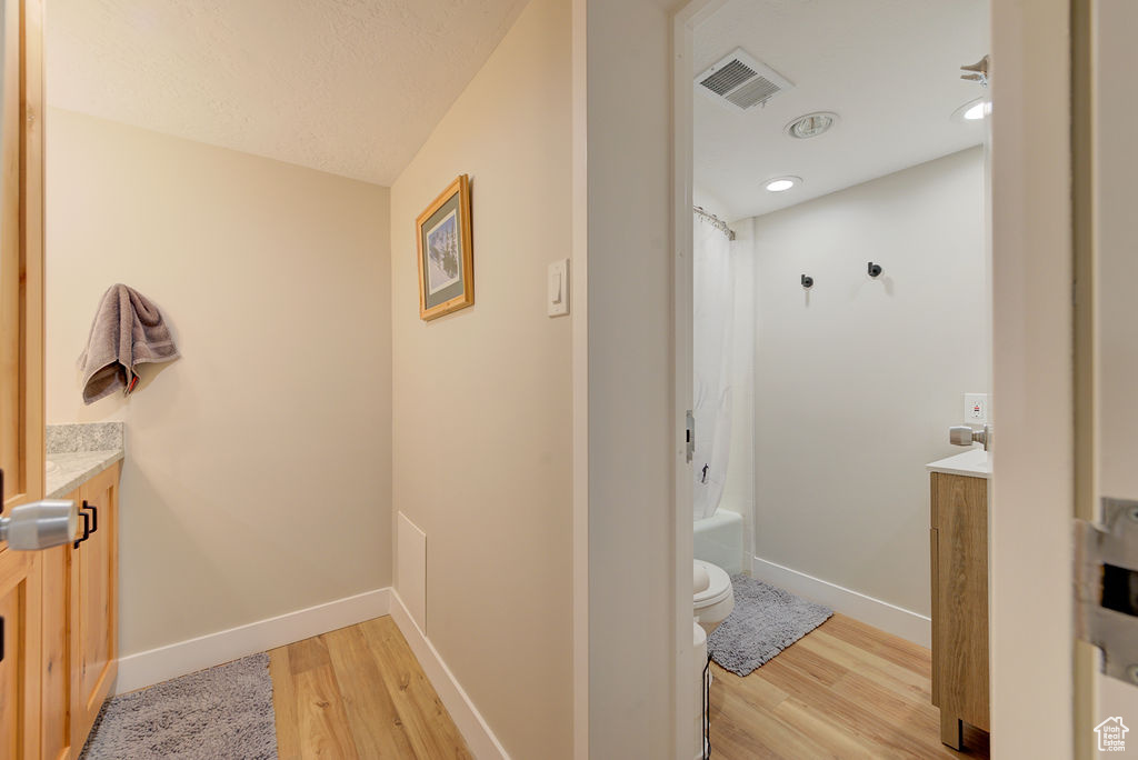 Full bath with vanity, wood finished floors, and shower / bath combo with shower curtain