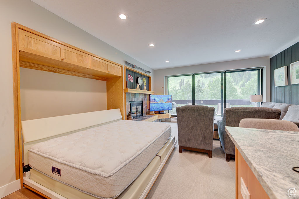 Bedroom featuring recessed lighting, access to outside, and a fireplace