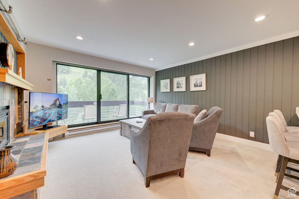 Living room with carpet flooring, recessed lighting, and a tiled fireplace