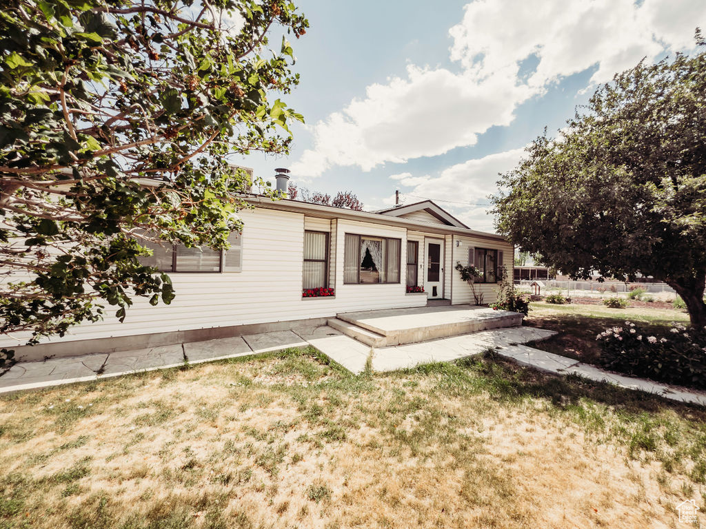 Back of property featuring a patio area and a yard