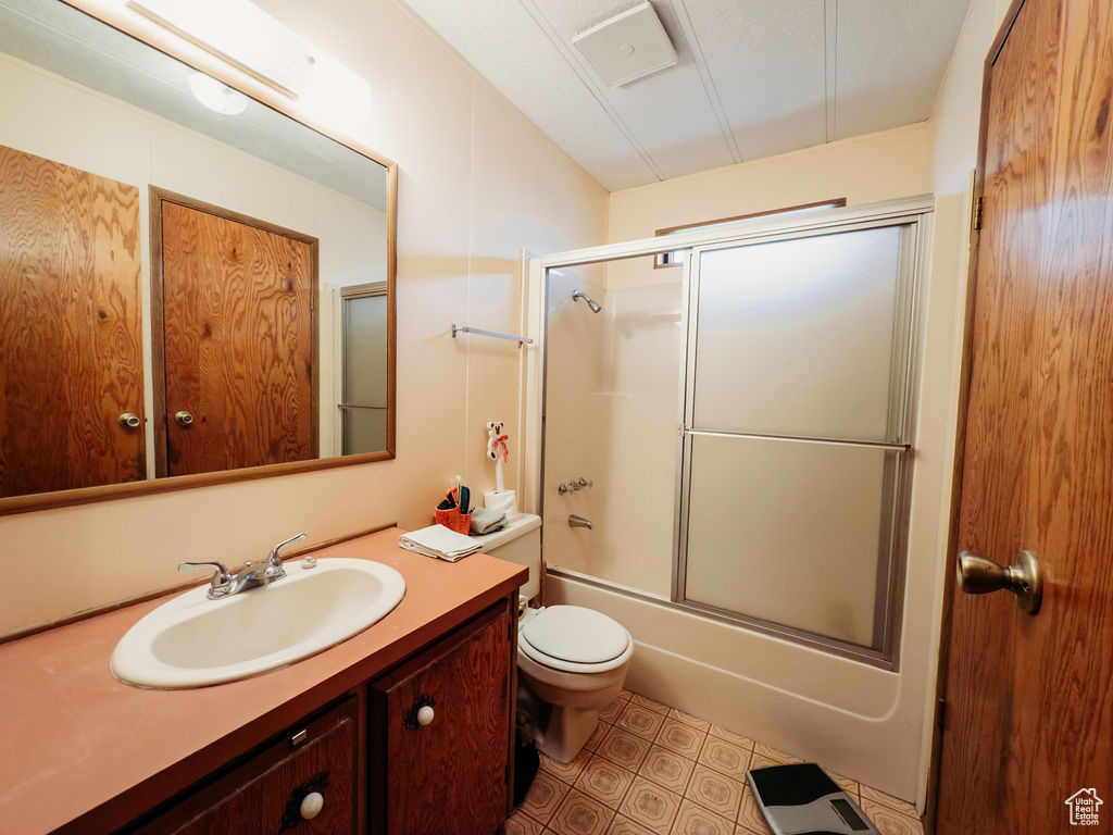 Full bath with vanity, enclosed tub / shower combo, and tile patterned floors
