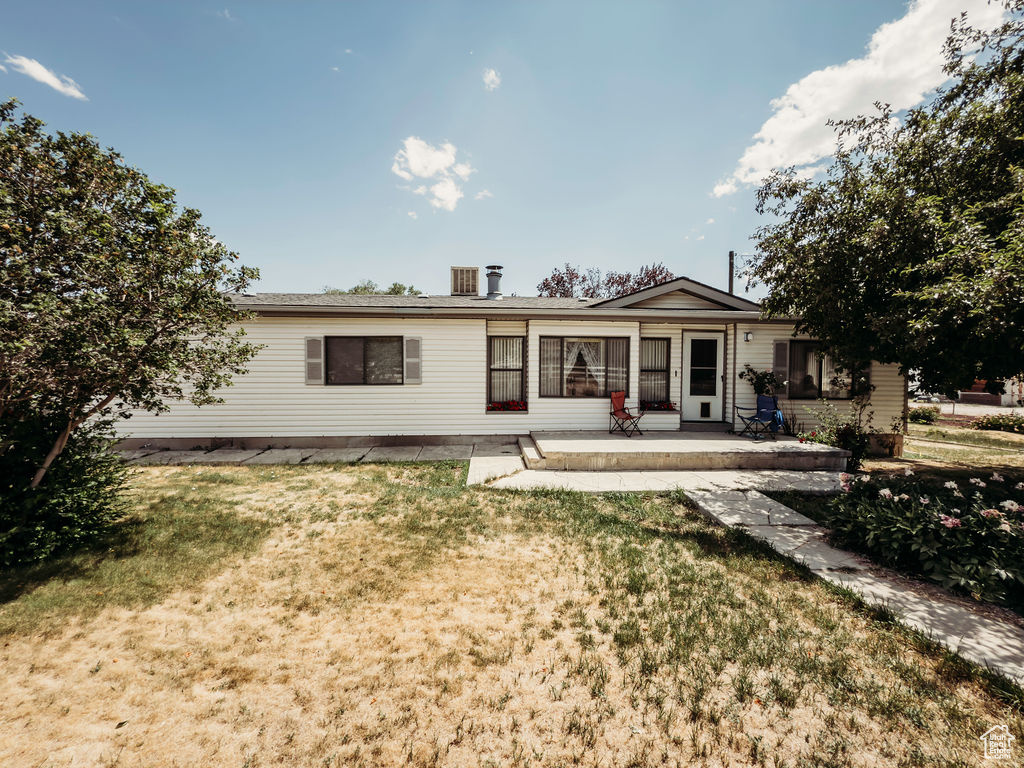 Back of property featuring a lawn and a patio area