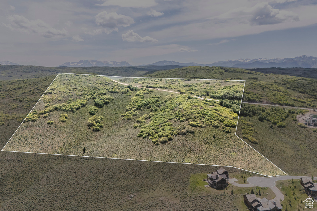Aerial view of property and surrounding area with property parcel outlined and a mountainous background