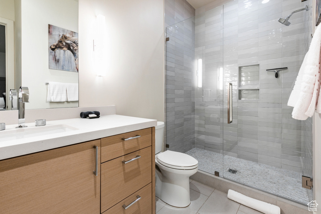 Full bath with vanity, a stall shower, and tile patterned flooring