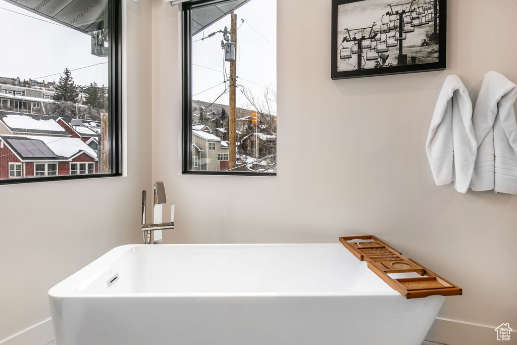 Full bath with a freestanding bath and baseboards