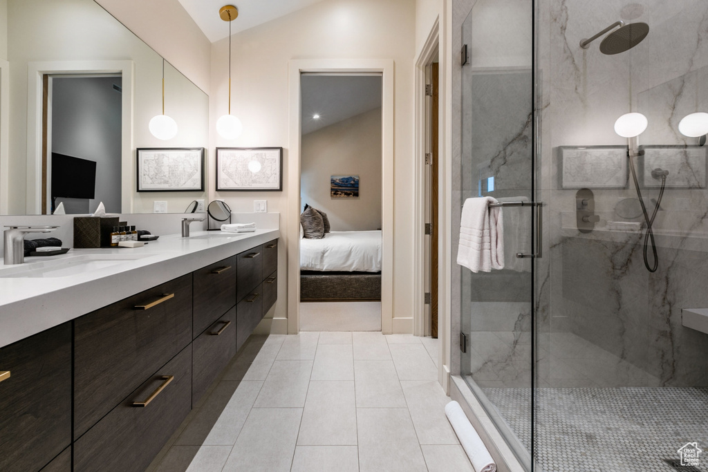Bathroom featuring double vanity, a marble finish shower, ensuite bathroom, vaulted ceiling, and tile patterned flooring