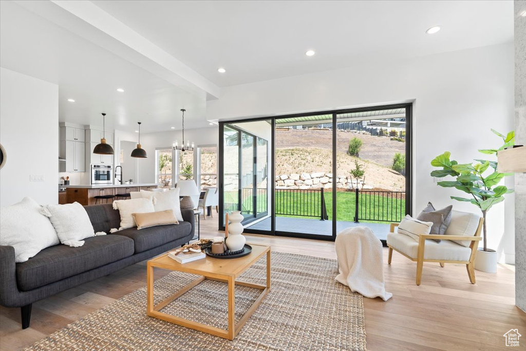 Living area featuring a chandelier, light wood-style floors, and recessed lighting