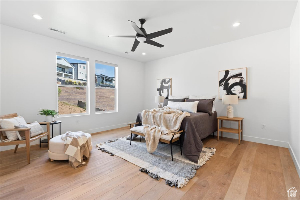 Bedroom with light wood-style floors, ceiling fan, and recessed lighting