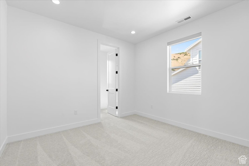 Carpeted empty room featuring recessed lighting
