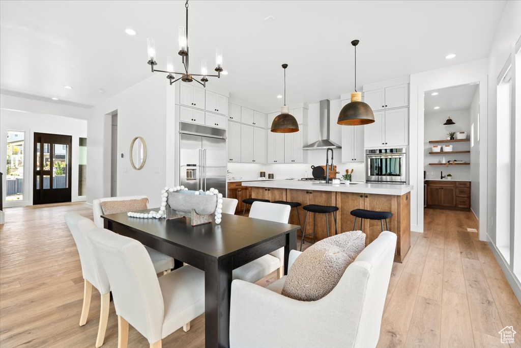 Dining area featuring light wood-style flooring, a chandelier, and recessed lighting