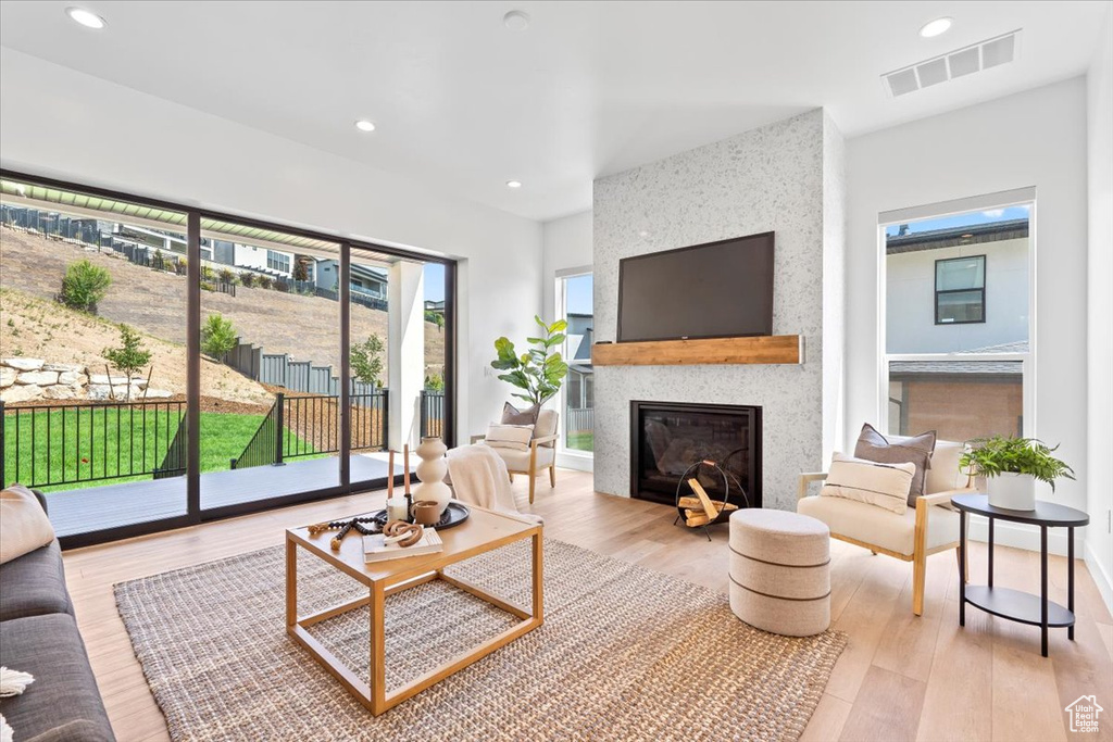 Living area with wood finished floors, recessed lighting, and a large fireplace