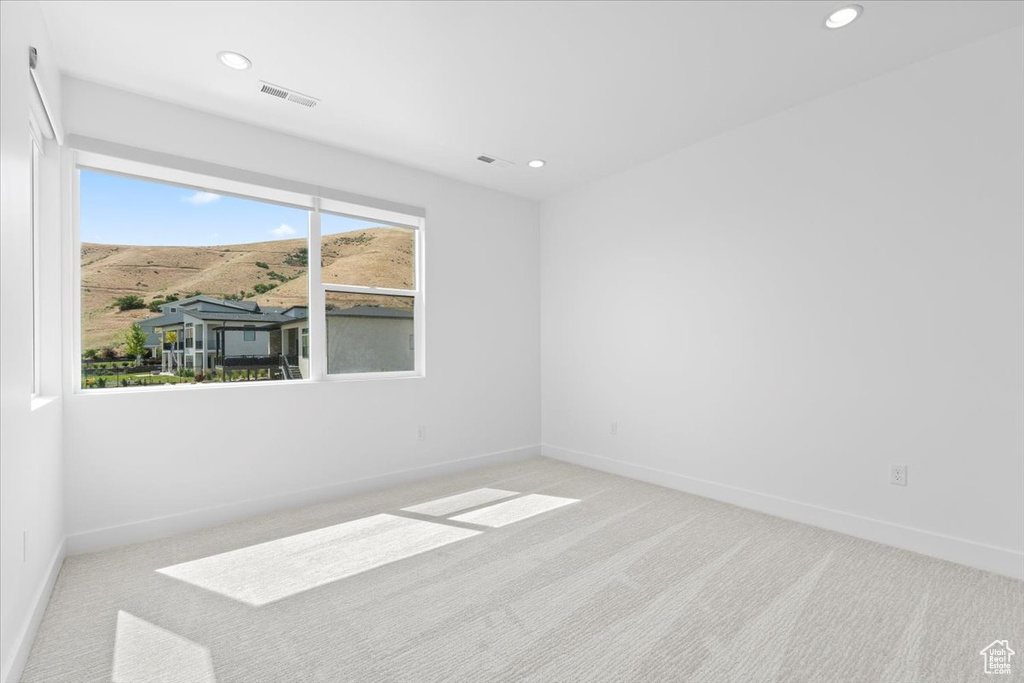 Unfurnished room with carpet floors, recessed lighting, and a mountain view