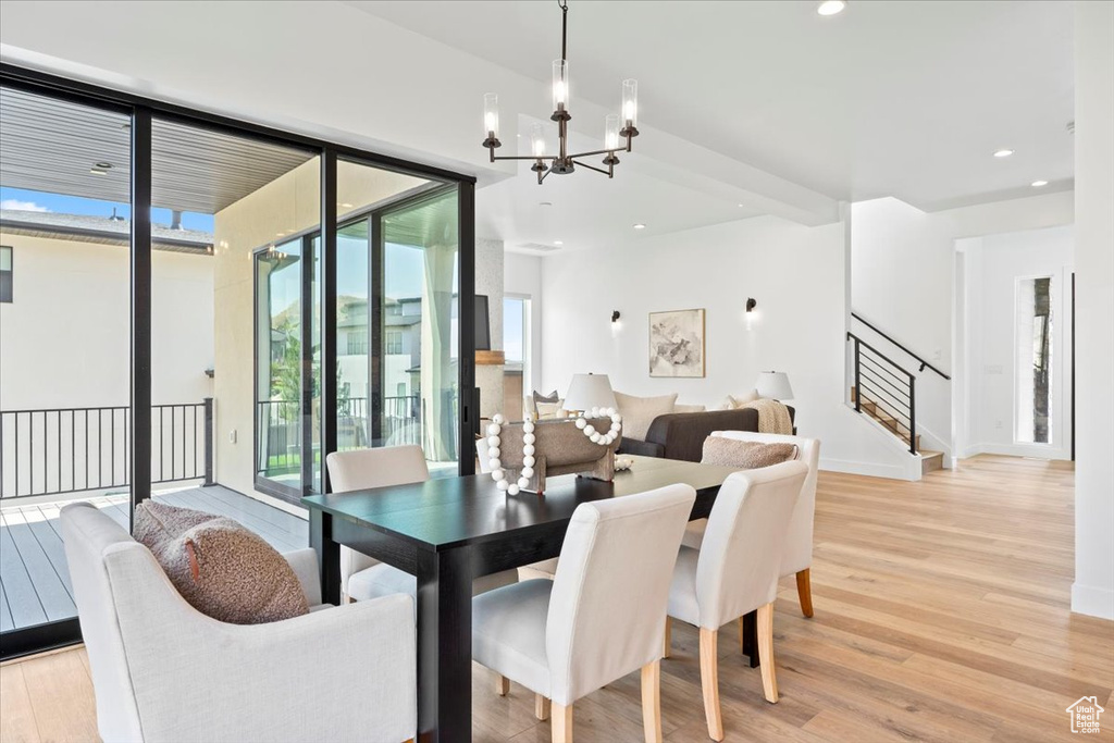 Dining area featuring a chandelier, light wood-style floors, stairs, and recessed lighting