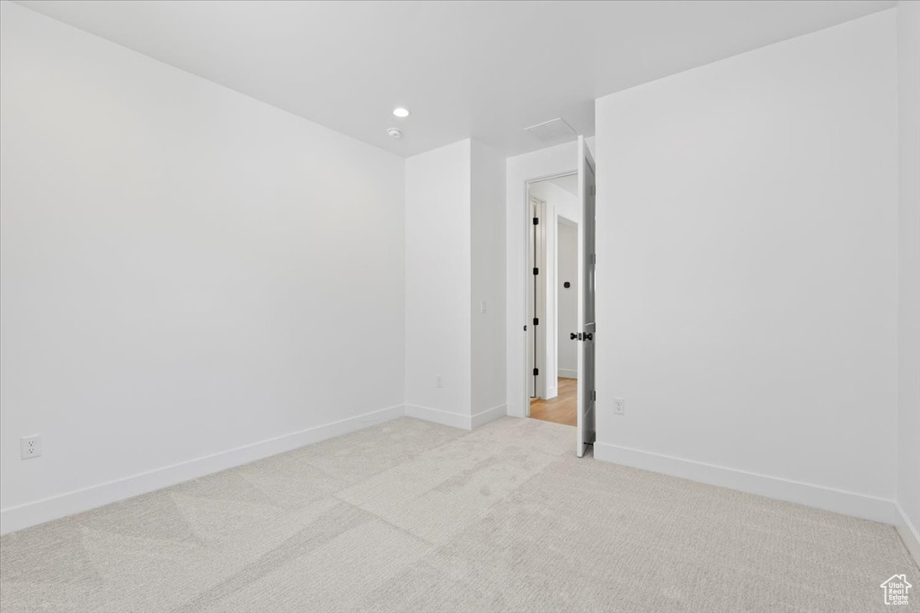 Spare room with light carpet and recessed lighting