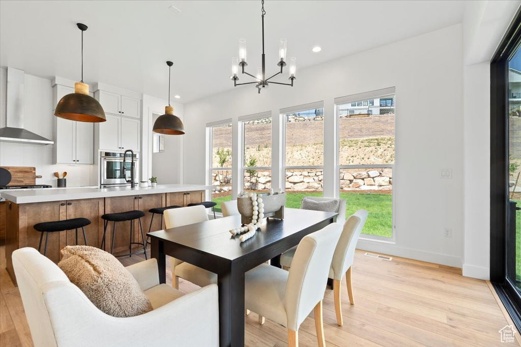 Dining space with recessed lighting, light wood finished floors, and a chandelier