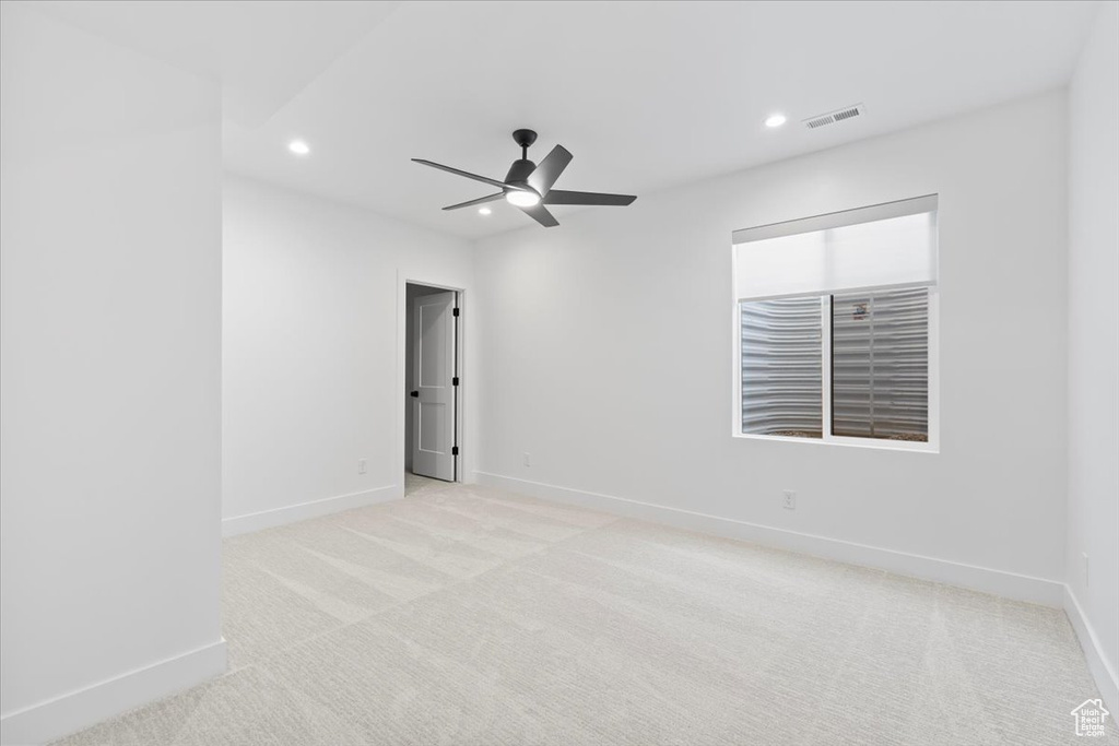 Empty room featuring recessed lighting, light colored carpet, and ceiling fan