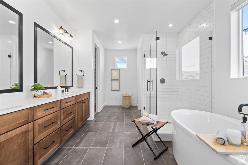 Full bath featuring a soaking tub, vanity, a shower stall, recessed lighting, and tile patterned flooring