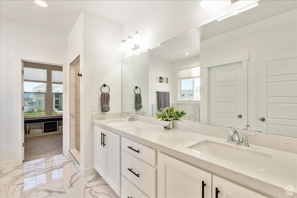 Full bath with recessed lighting, double vanity, and marble finish floors