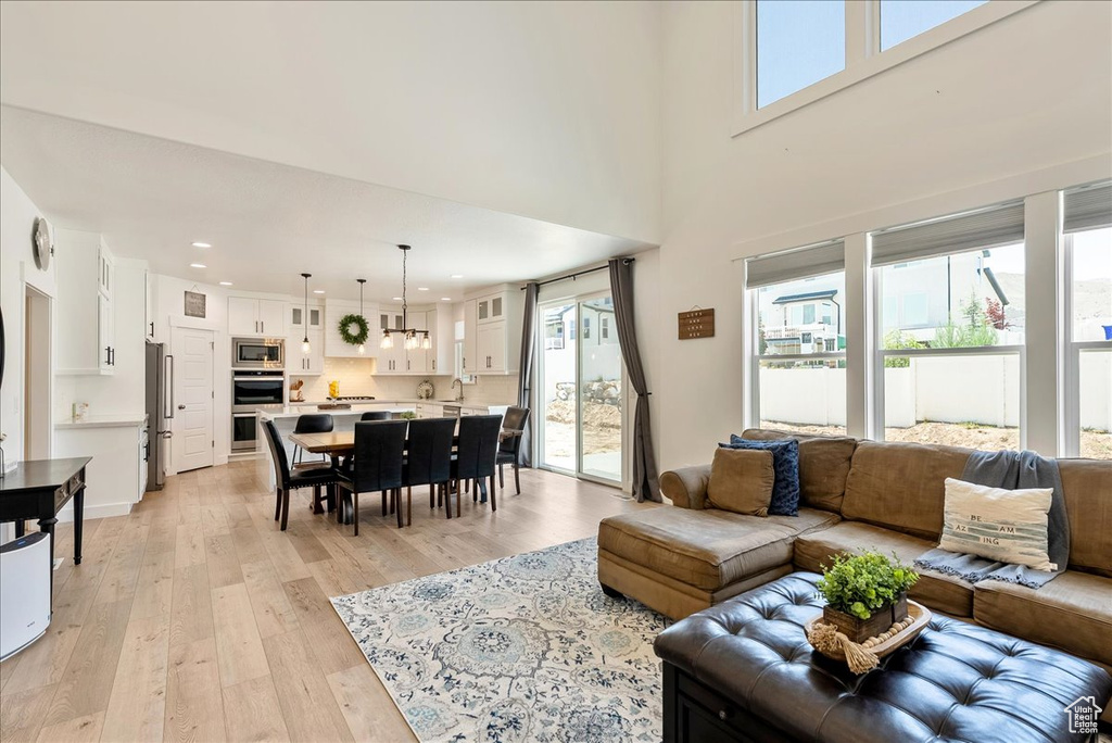 Living room with light wood-style flooring and recessed lighting